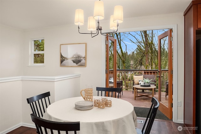 dining area featuring an inviting chandelier, plenty of natural light, crown molding, and dark hardwood / wood-style floors