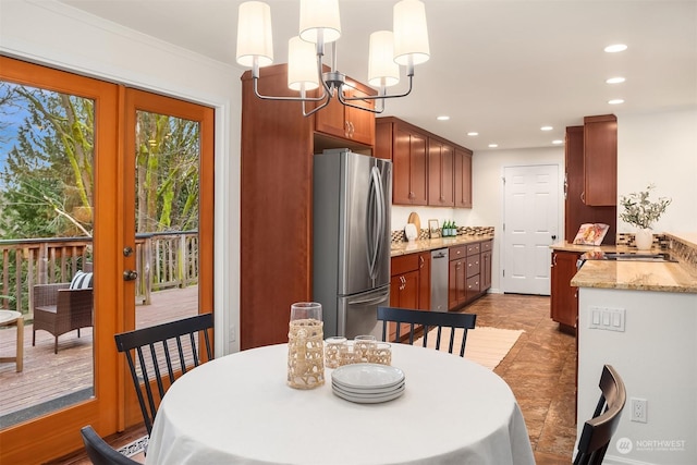 dining room with french doors, crown molding, and a chandelier