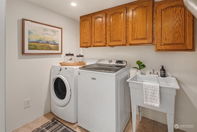 laundry room with cabinets, light tile patterned floors, washer and clothes dryer, and sink