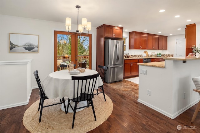 dining area with a notable chandelier, dark wood-type flooring, and ornamental molding