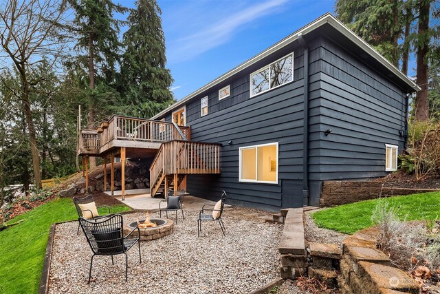 back of house with a fire pit, a patio area, and a wooden deck