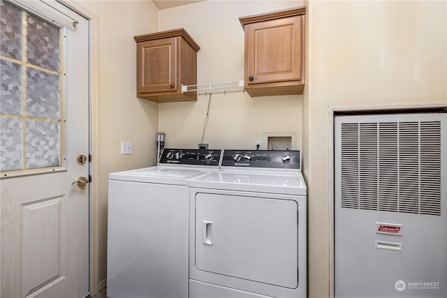 washroom with washing machine and clothes dryer and cabinets