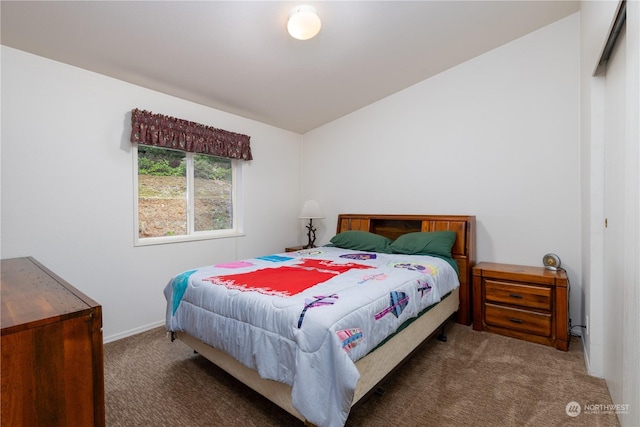 bedroom with vaulted ceiling and dark colored carpet