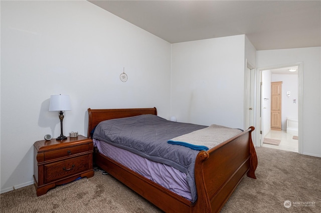 bedroom featuring ensuite bath and light colored carpet