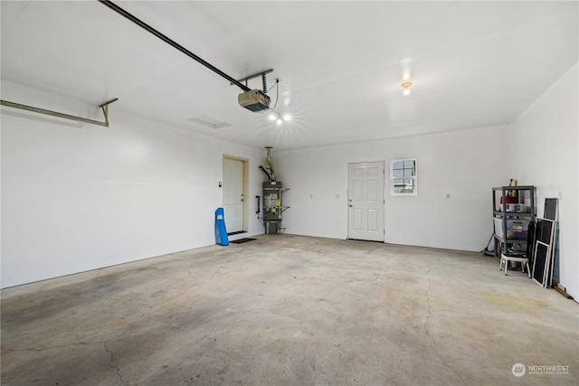 garage featuring a garage door opener and water heater