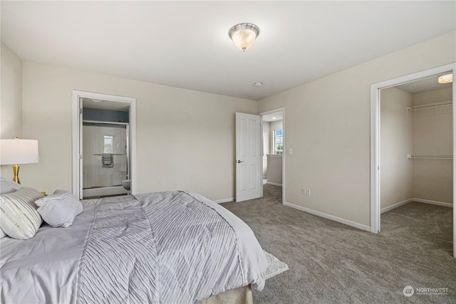 carpeted bedroom with ensuite bathroom, a closet, and a walk in closet