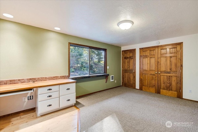 unfurnished office with light colored carpet and a textured ceiling