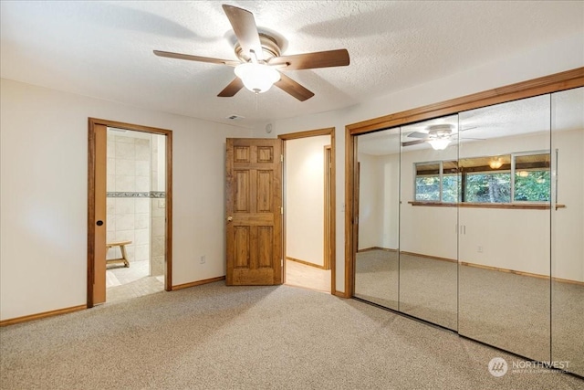 unfurnished bedroom with ceiling fan, ensuite bathroom, carpet floors, a textured ceiling, and a closet