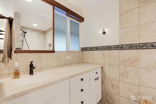 bathroom featuring vanity and tile walls