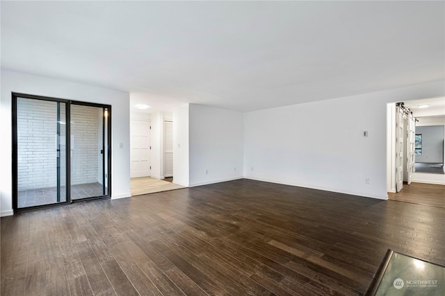 unfurnished living room with baseboards and wood finished floors