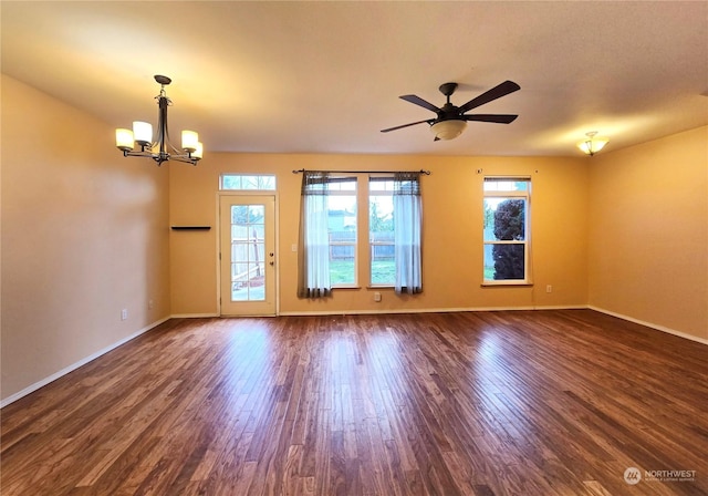 unfurnished room featuring ceiling fan with notable chandelier and dark wood-type flooring