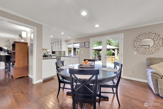 dining space with french doors, crown molding, and dark hardwood / wood-style flooring