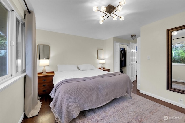 bedroom featuring dark hardwood / wood-style flooring, an inviting chandelier, and a closet