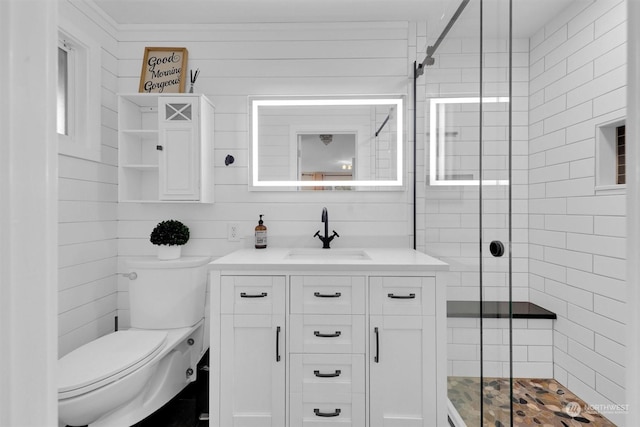 bathroom featuring toilet, wooden walls, vanity, and walk in shower