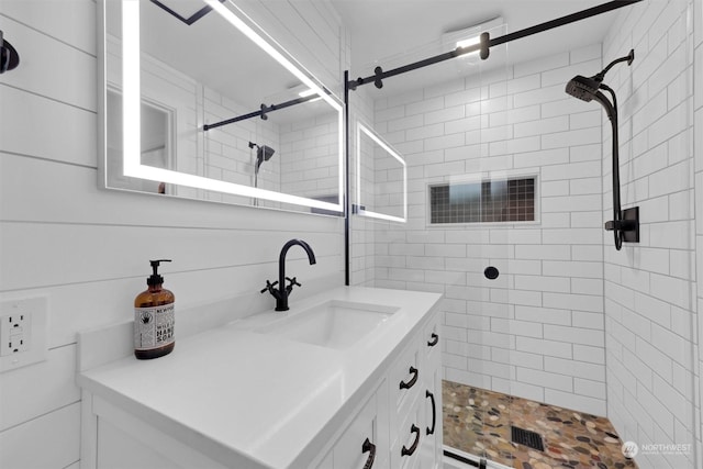 bathroom featuring tiled shower and vanity