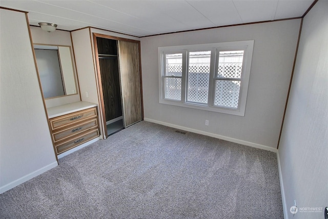 unfurnished bedroom featuring a closet, carpet floors, and ornamental molding