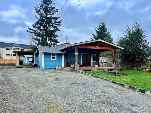 view of front of house with french doors, a front yard, and covered porch