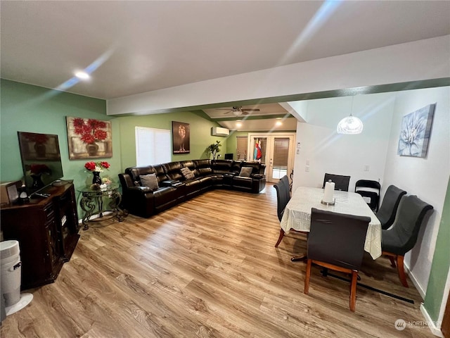 living room with french doors, an AC wall unit, light wood-type flooring, and ceiling fan