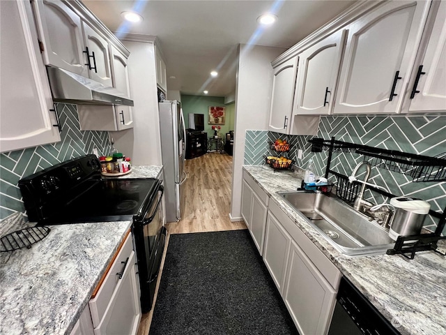 kitchen with sink, white cabinets, tasteful backsplash, and black appliances