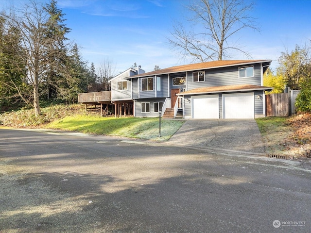 split foyer home with a garage, a deck, and a front lawn