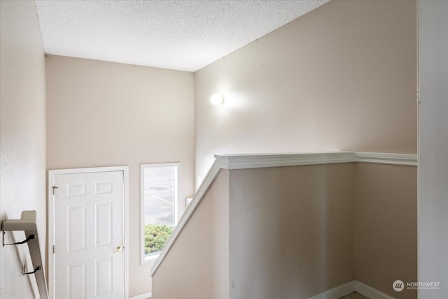 staircase featuring a textured ceiling