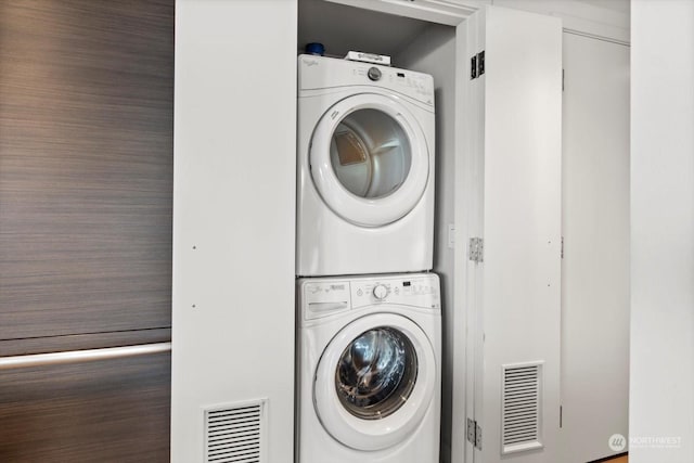 washroom featuring stacked washer and clothes dryer