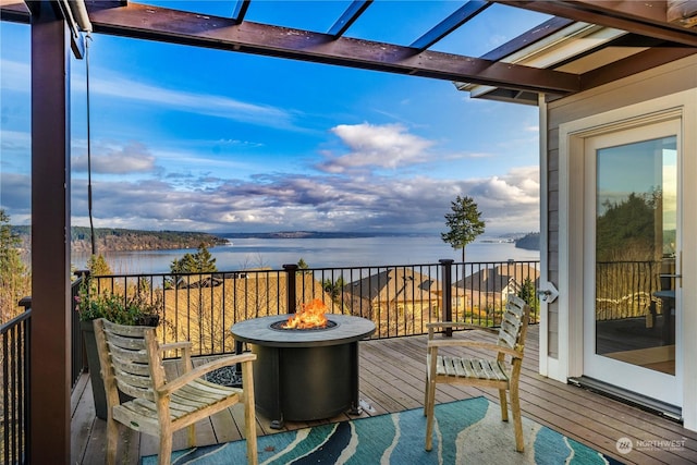 balcony featuring an outdoor fire pit and a water view