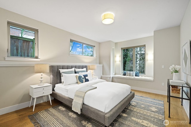 bedroom with baseboards and wood finished floors