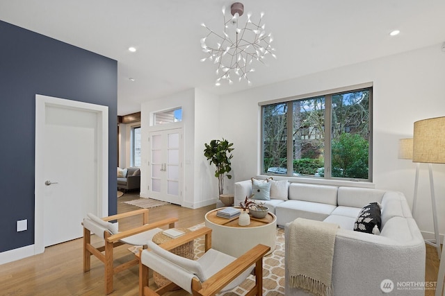 living room featuring baseboards, recessed lighting, a chandelier, and light wood-style floors