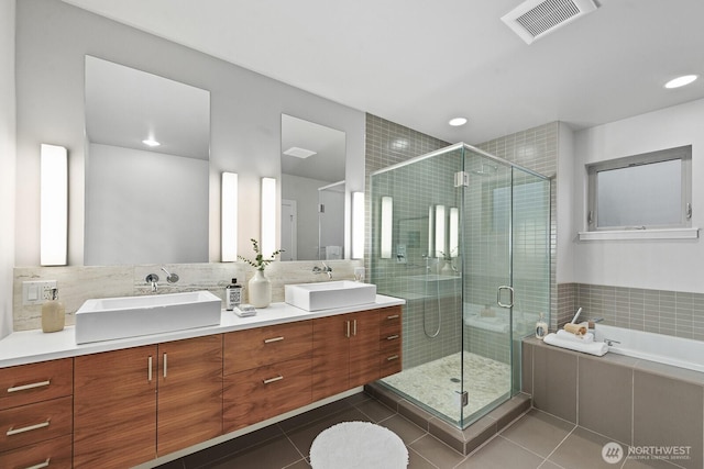 full bathroom with a stall shower, visible vents, a sink, and tile patterned floors