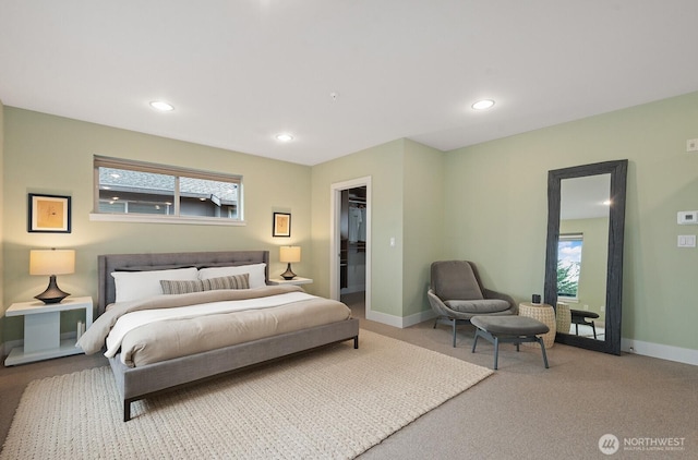 carpeted bedroom with a spacious closet, baseboards, and recessed lighting