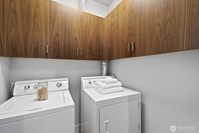 washroom with washing machine and dryer and cabinet space