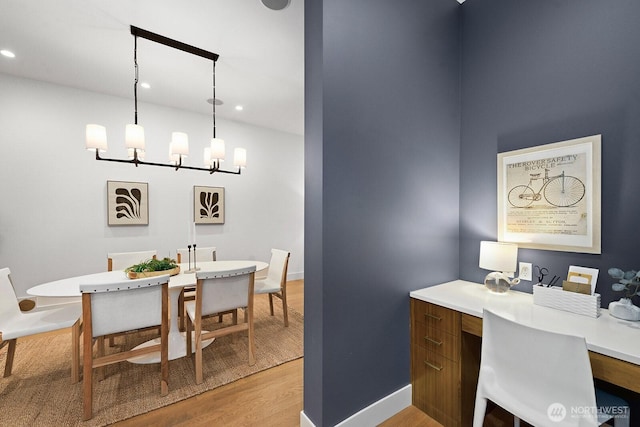 dining room featuring baseboards, built in study area, an inviting chandelier, light wood-type flooring, and recessed lighting