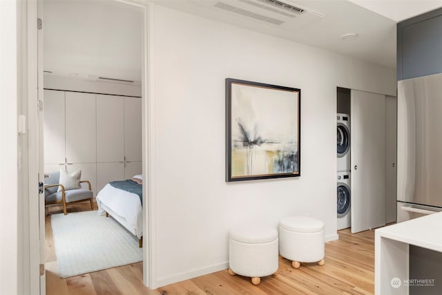 interior space with light hardwood / wood-style flooring and stacked washer / dryer