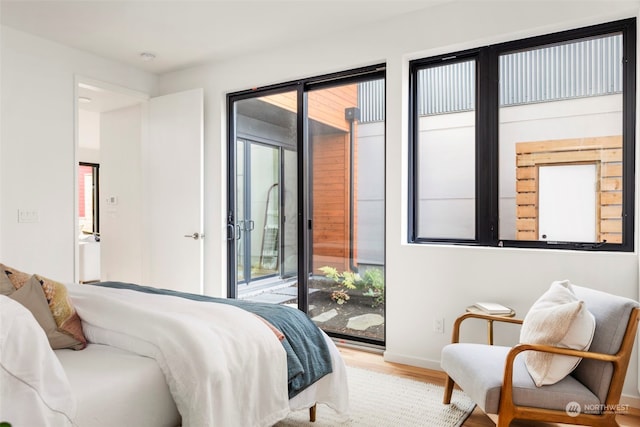 bedroom featuring wood-type flooring and access to exterior