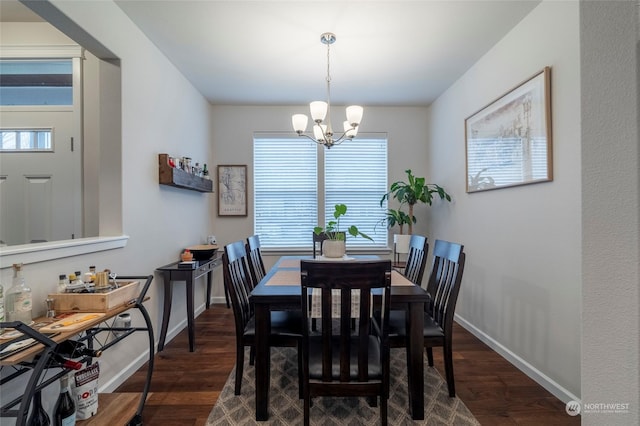 dining area with a notable chandelier and dark hardwood / wood-style floors