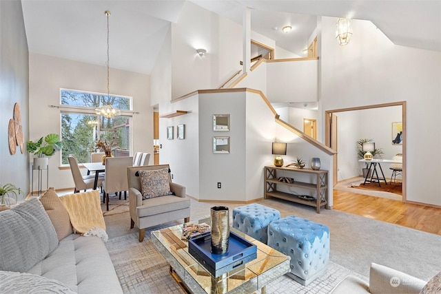 living room featuring hardwood / wood-style flooring, high vaulted ceiling, and a chandelier