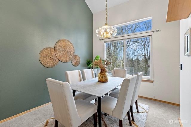 dining area with a chandelier, light carpet, and vaulted ceiling