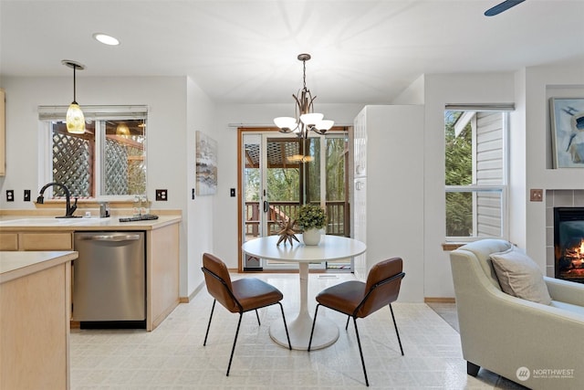 dining space featuring sink, an inviting chandelier, and a fireplace