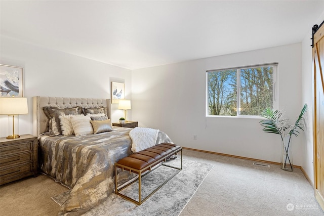 carpeted bedroom featuring a barn door