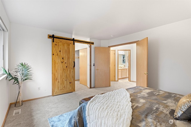 carpeted bedroom with ensuite bathroom and a barn door