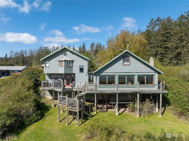 rear view of house with a lawn and a deck