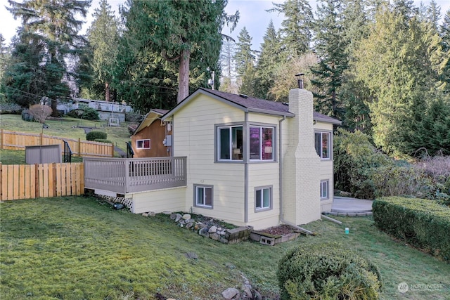 back of property featuring a yard and a deck