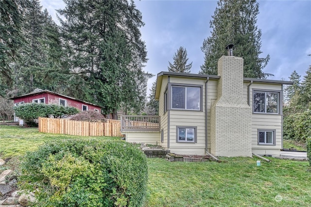 rear view of house with a yard and a wooden deck