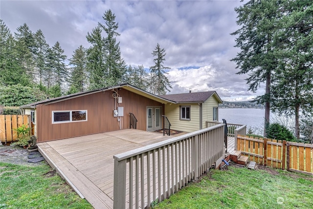 back of property featuring a lawn and a deck with water view