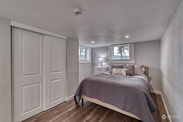 bedroom featuring a closet, dark hardwood / wood-style flooring, and a textured ceiling