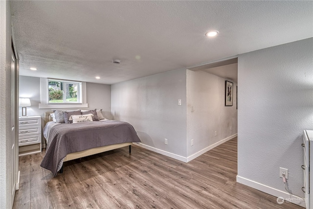 bedroom featuring hardwood / wood-style flooring and a textured ceiling