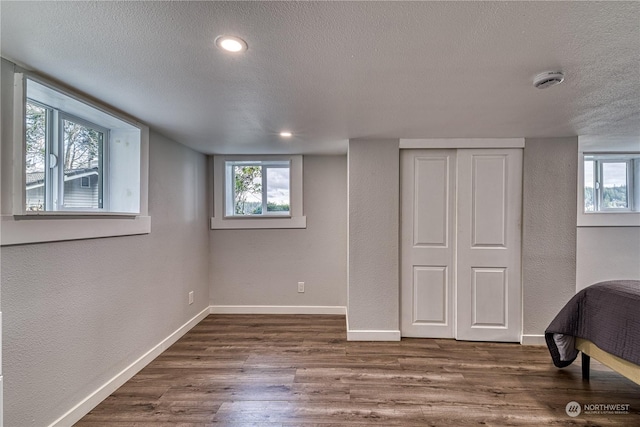 bedroom featuring a textured ceiling and dark hardwood / wood-style floors