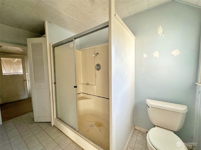 bathroom featuring a shower with shower door and toilet