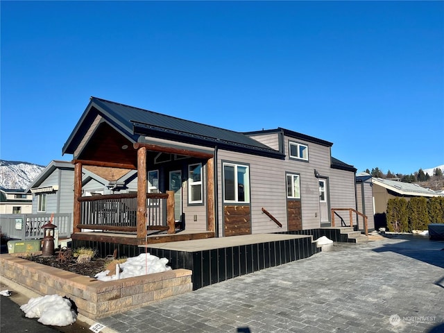 back of property with a porch and a mountain view